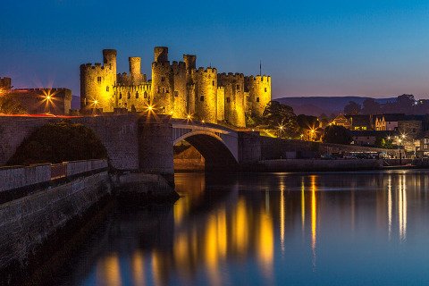 Conwy Castle in North Wales United Kingdom at night with the Lights Reflecting in the river below