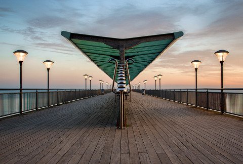 Architecture of Boscombe Pier jetty wooden walkway over the ocean in England at sunset