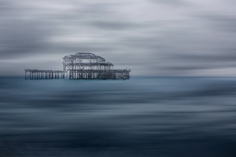 Seascape long exposure old derelict Brighton Pier in England in the Ocean in winter blue hues