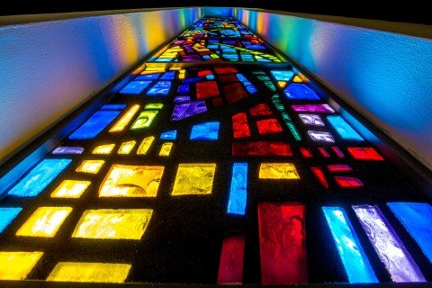 architecture stained glass window of church lit up at night viewed vertically