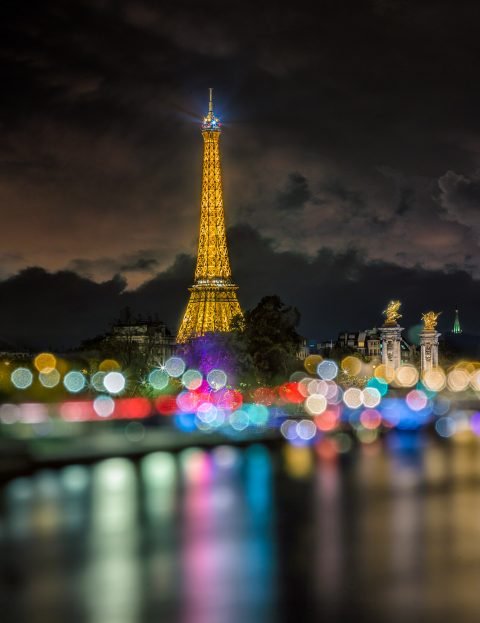 Paris view along river Seine with Eiffel Tower at Night in Lights Bokeh soft focus
