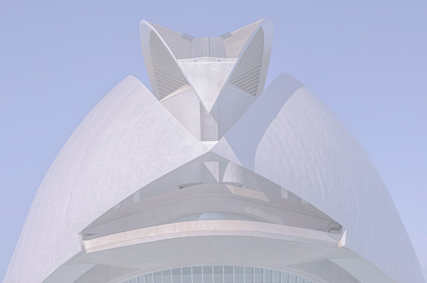 White sculptural modern building photographed against a pale sky.