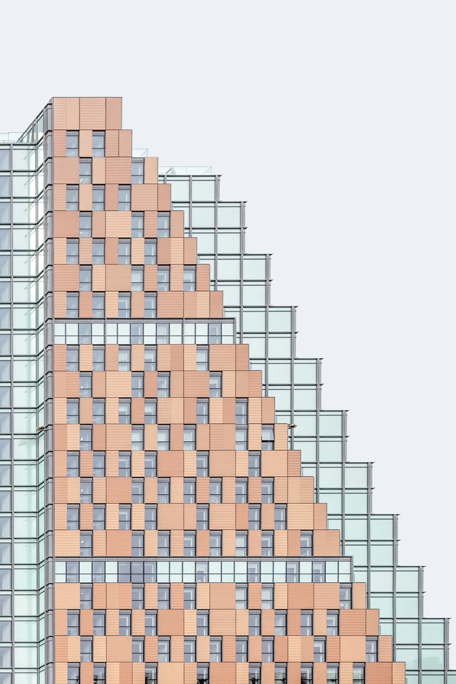 Stepped terracotta and glass facade with repeating windows.