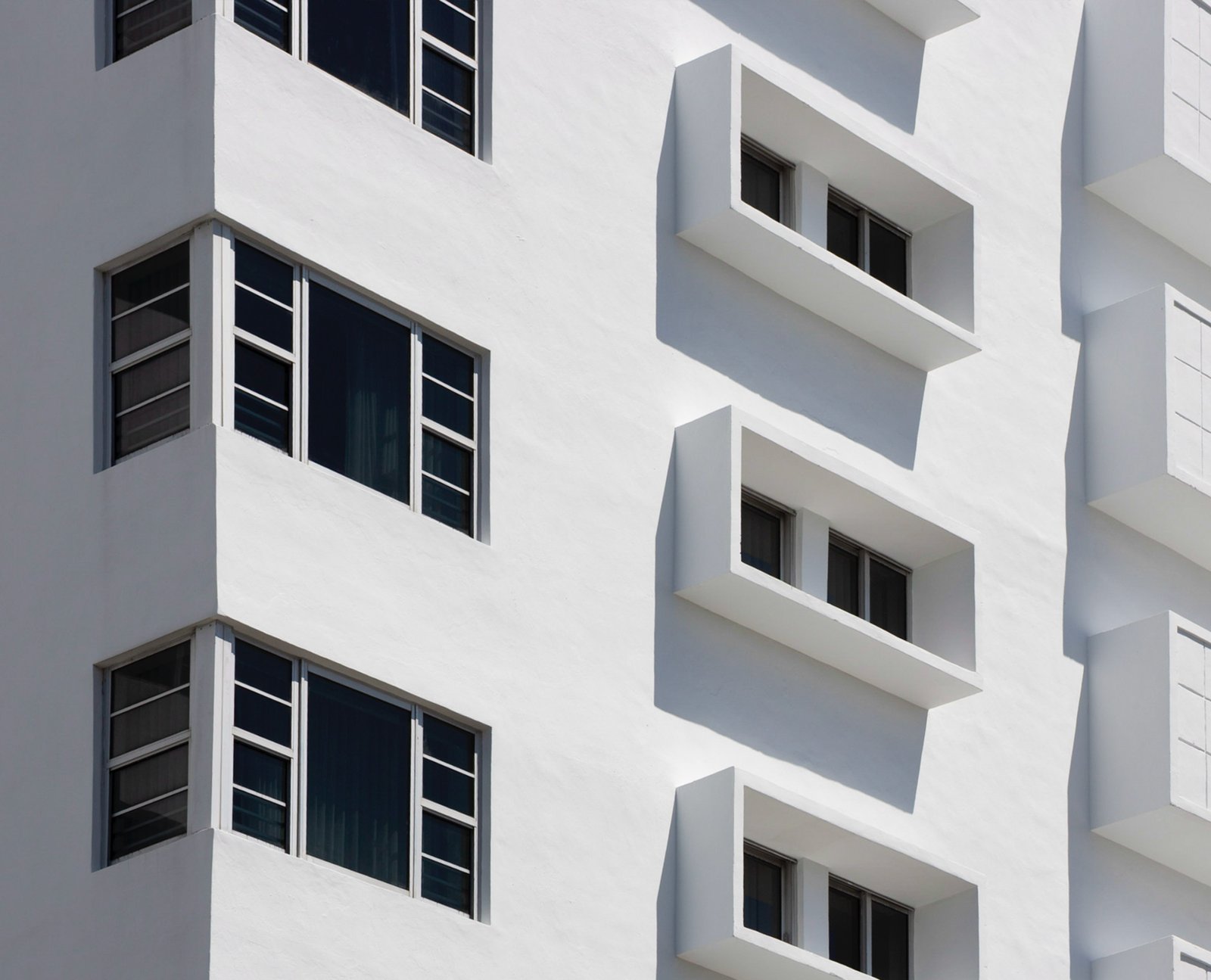 White Art Deco facade with projecting rectangular windows and dark trim.