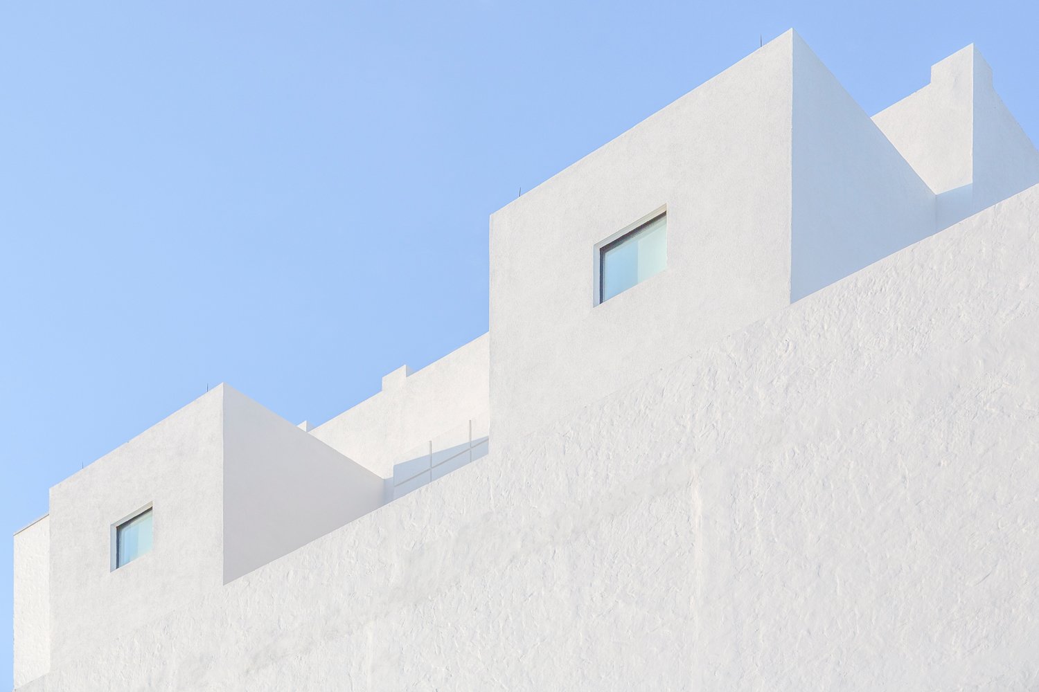 high key white stone block building with blue sky